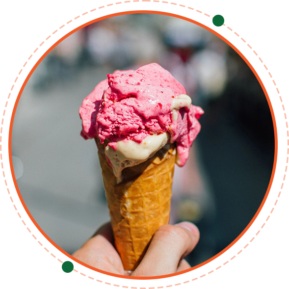 A person holding up an ice cream cone with pink frosting.